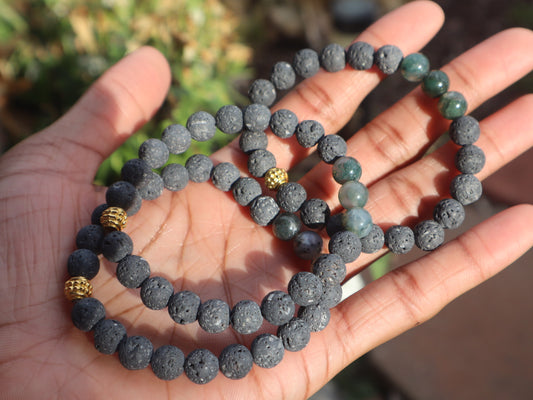 Two beaded bracelets on a hand with a blurred natural background