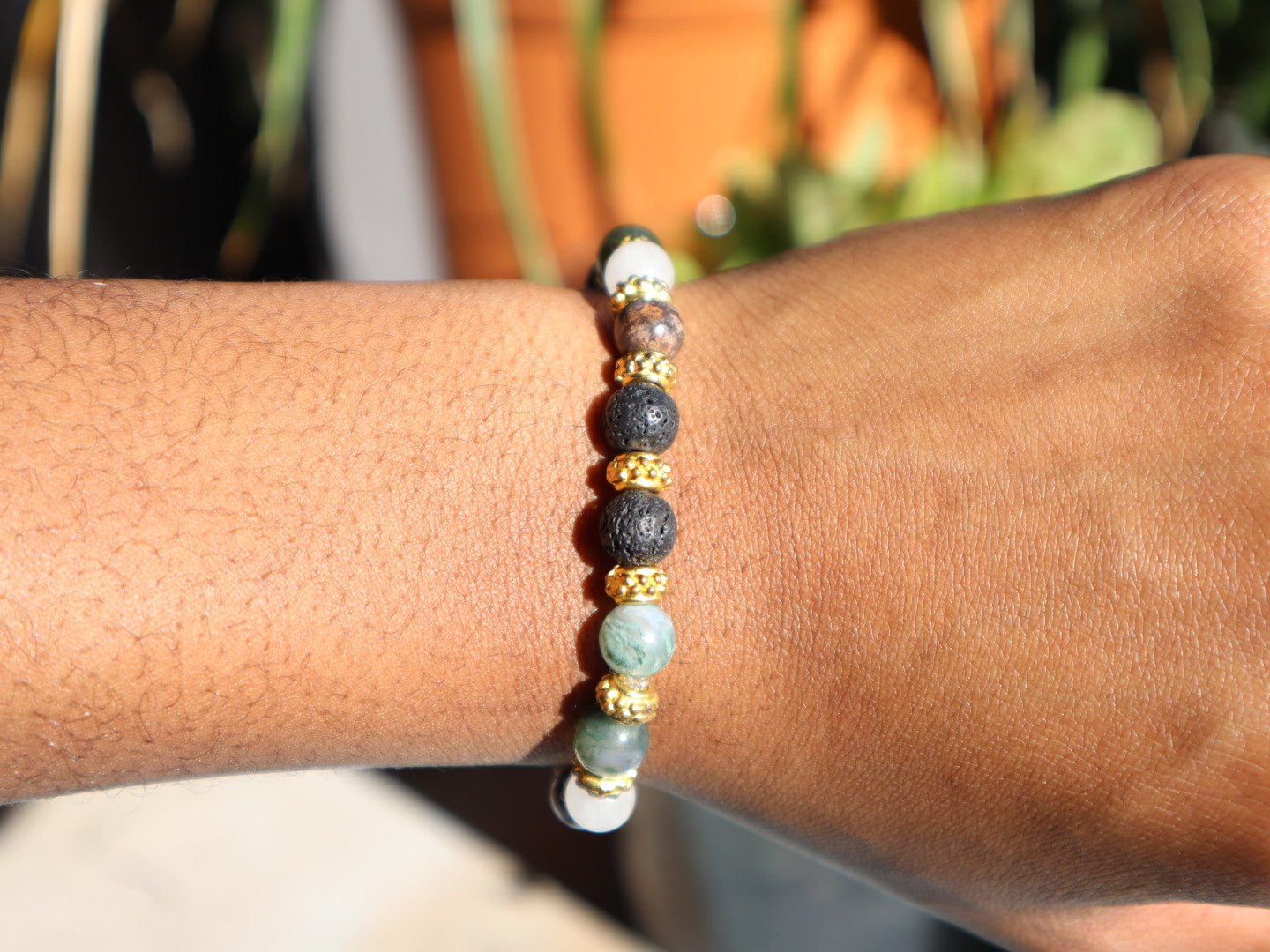 Bracelet with beads on a wrist against a blurred natural background