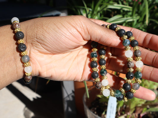 Hand holding two beaded bracelets with a natural background