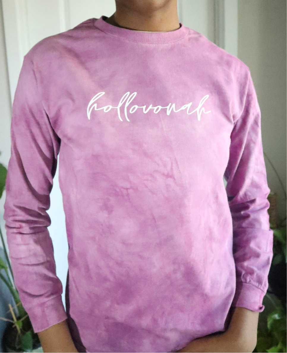 Person wearing a pink tie-dye long-sleeve shirt with 'hollovonah' text.