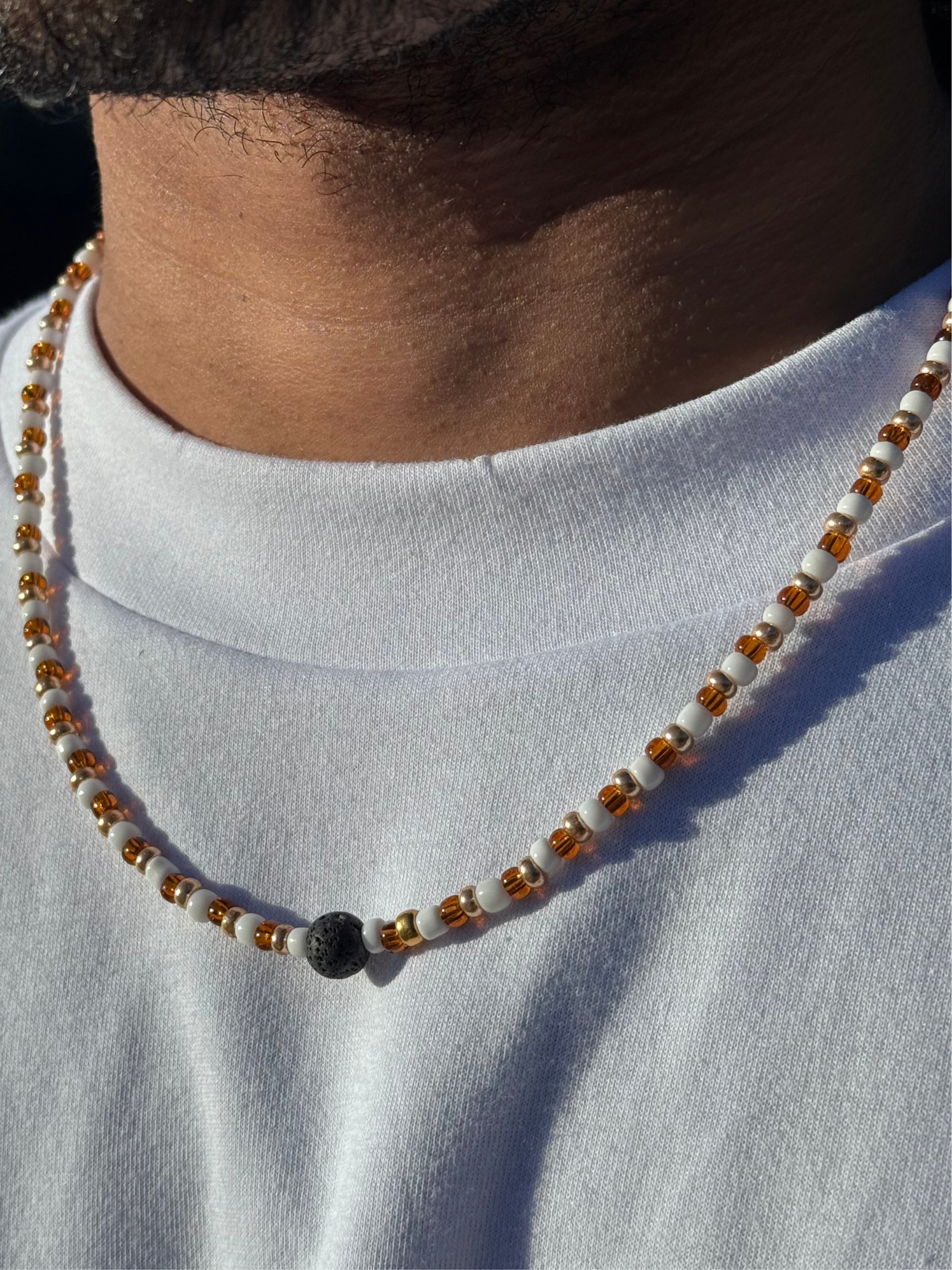 Necklace with beads worn by a person on a plain background