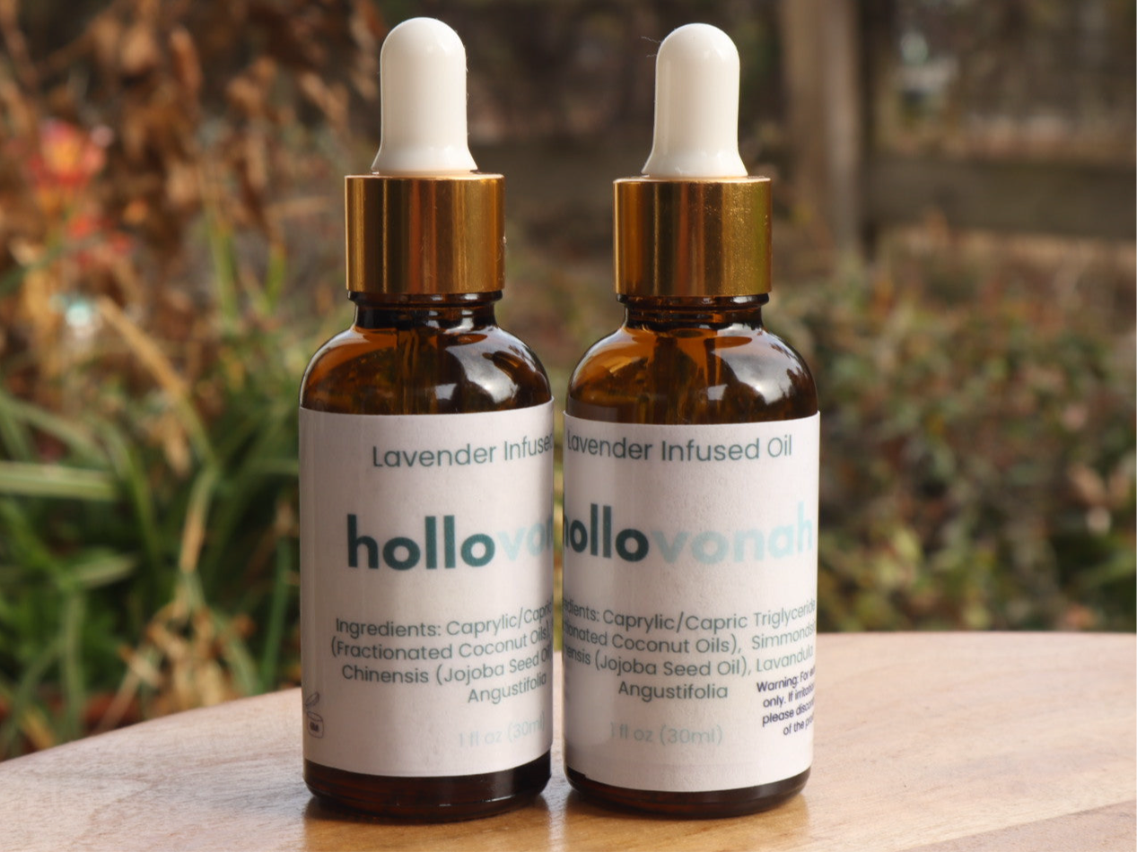 Two bottles of lavender infused oil with droppers on a wooden surface with a blurred natural background.