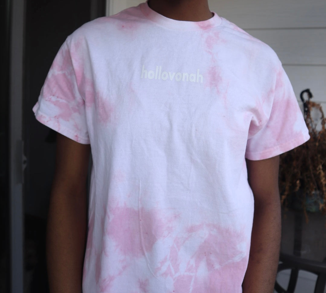 Person wearing a pink tie-dye t-shirt with 'hollovonah' text on a black background