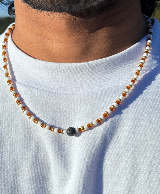 Necklace with beads worn by a person on a white shirt