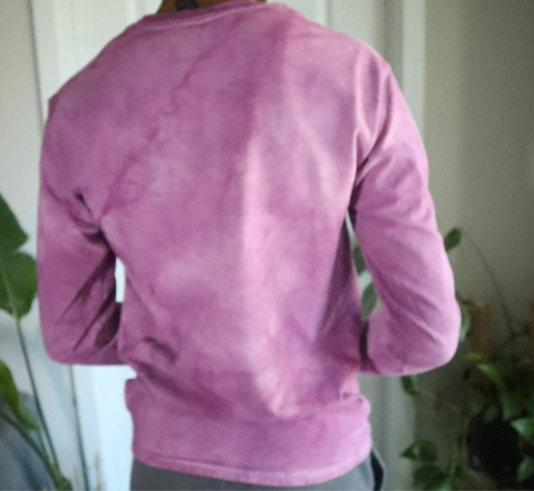 Purple long-sleeve shirt worn by a person with a neutral background