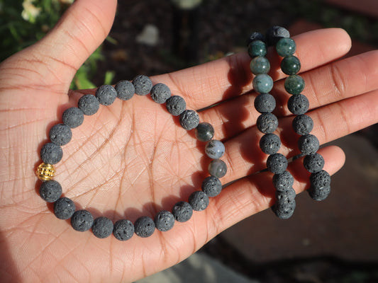 Two beaded bracelets on a hand with a blurred natural background