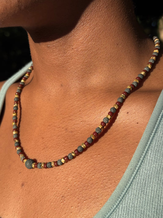 Close-up of a beaded necklace on a person's neck with a blurred background