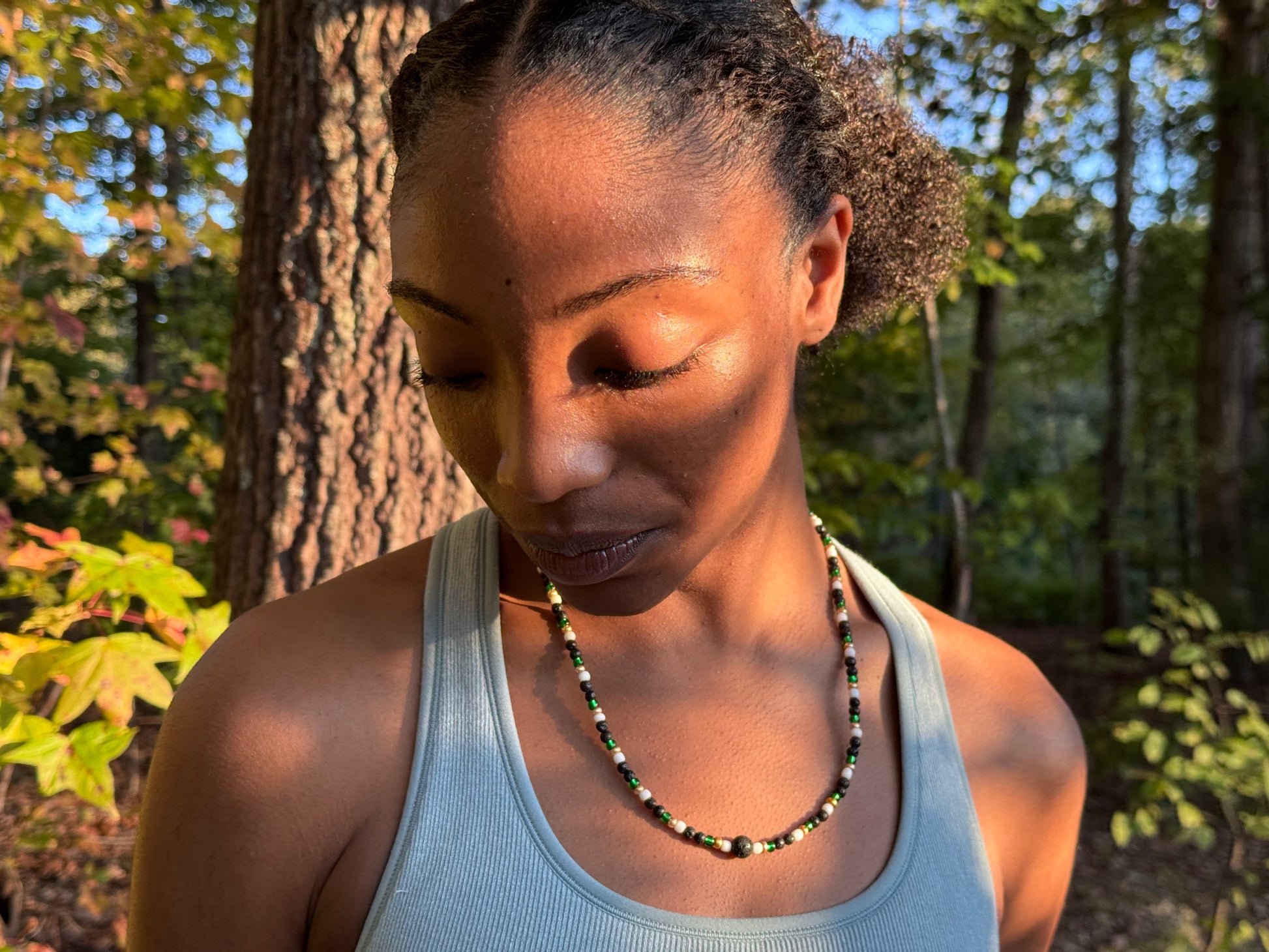 Woman in a gray tank top standing in a forest