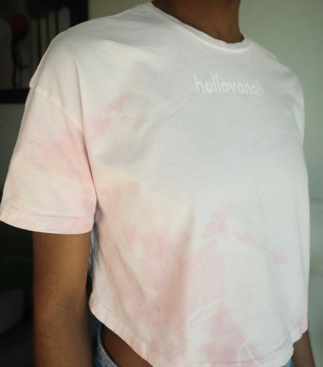 Person wearing a tie-dye t-shirt with 'hollovonah' branding.