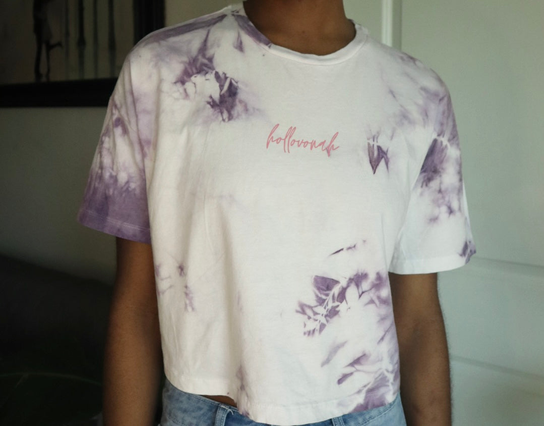 Person wearing a tie-dye t-shirt with butterfly designs and 'hollovonah' branding.
