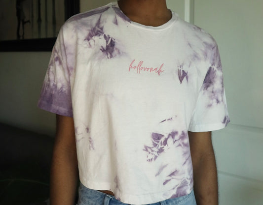 Person wearing a tie-dye t-shirt with butterfly designs and 'hollovonah' branding.