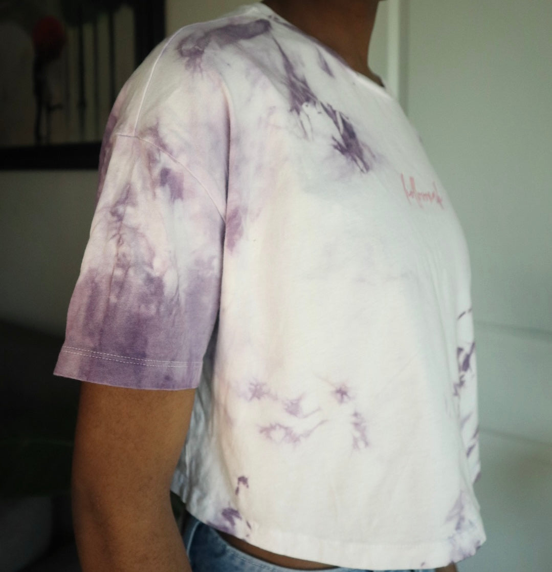 Person wearing a tie-dye t-shirt with purple and white patterns.
