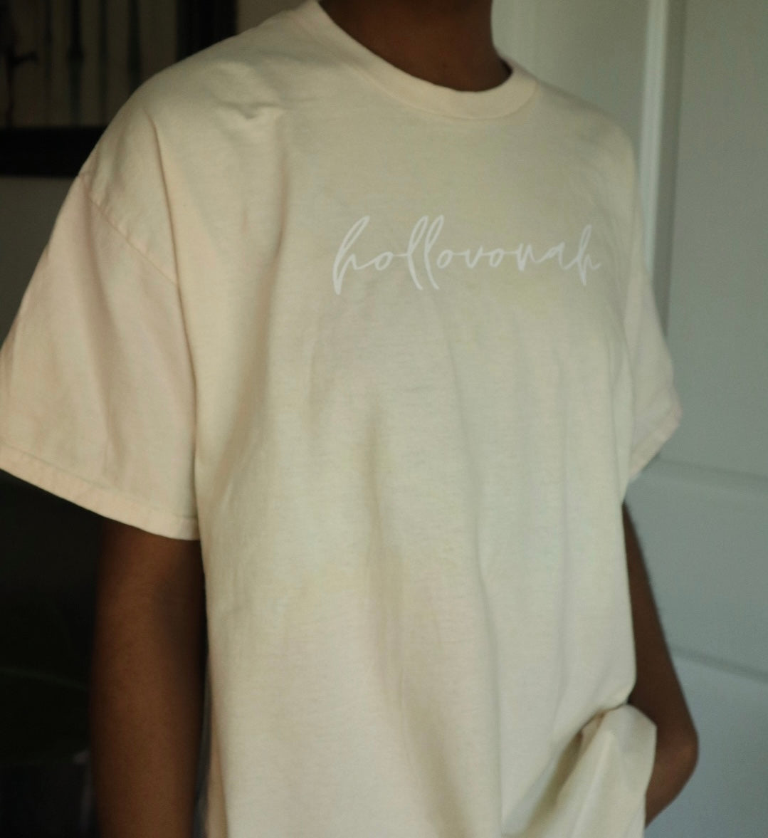peach t-shirt with 'hollovonah' text worn by a person indoors.