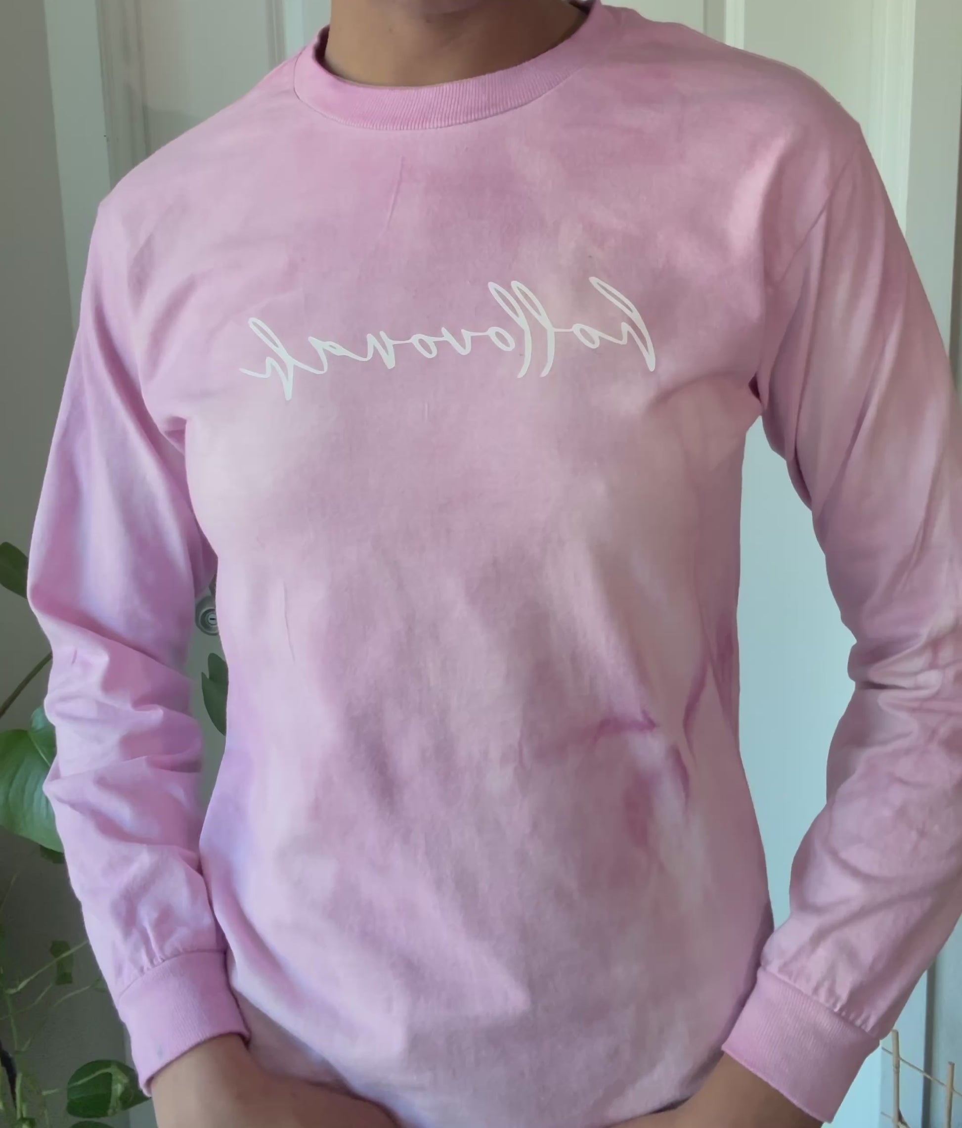 Person modeling a pink long sleeve shirt with the branding hollovonah.